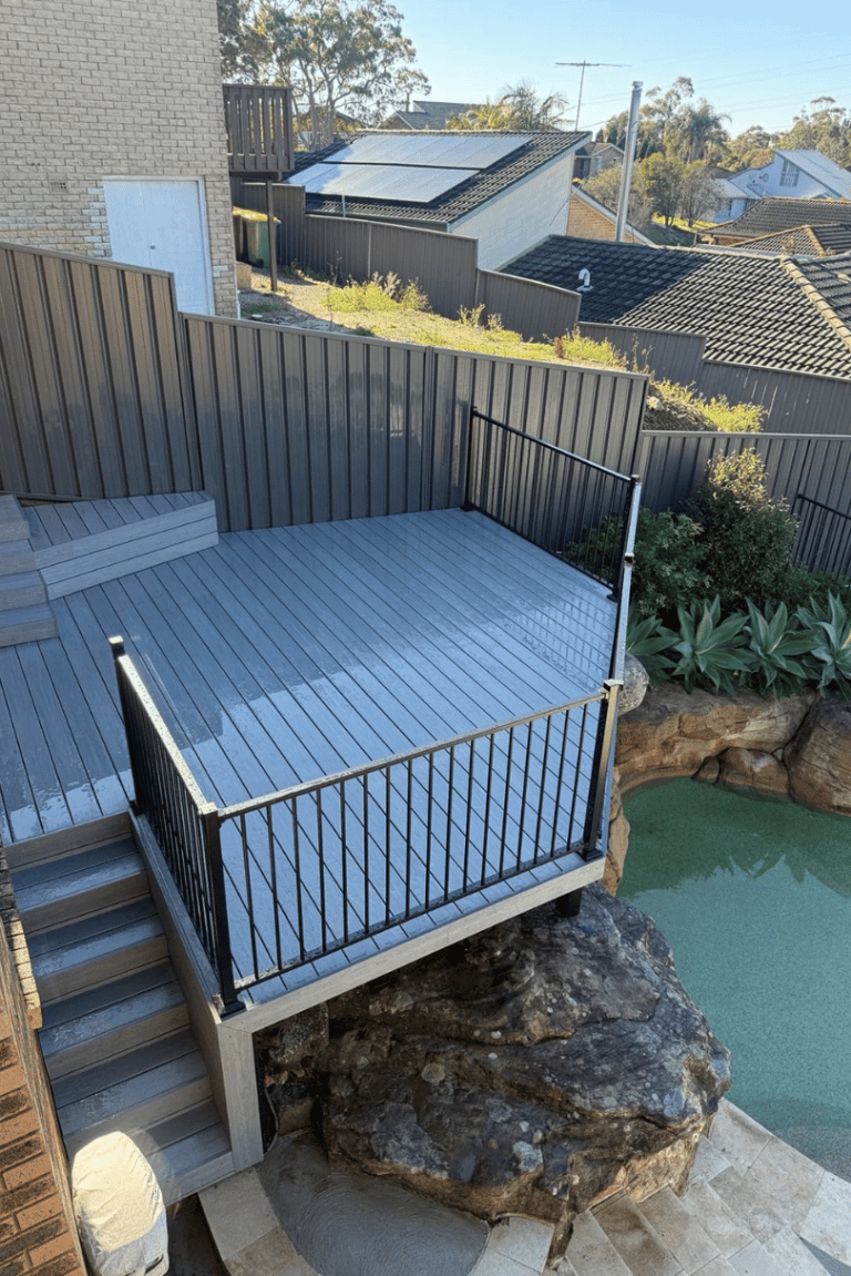 Grey deck with black balustrade and stairs above a rock garden