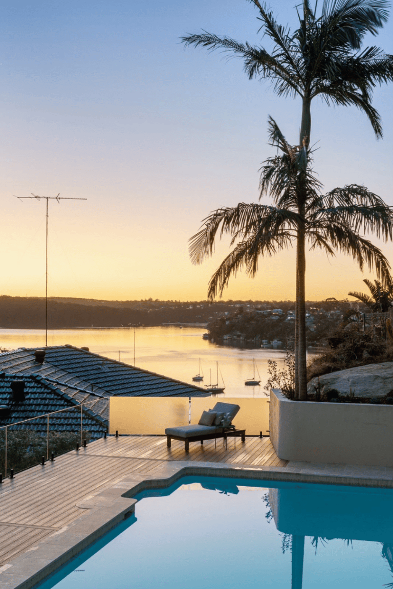 Poolside deck with water views at sunset